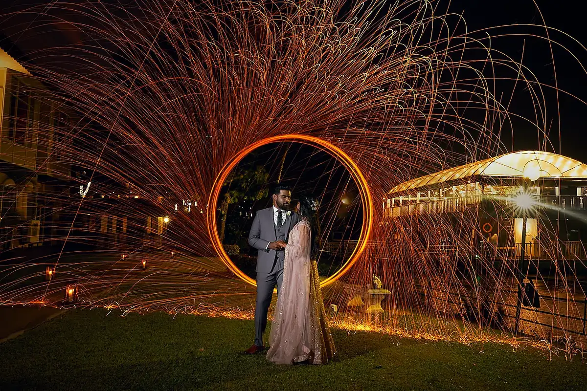 A couple inside a ring of golden sparks at night, photographed by Embrace